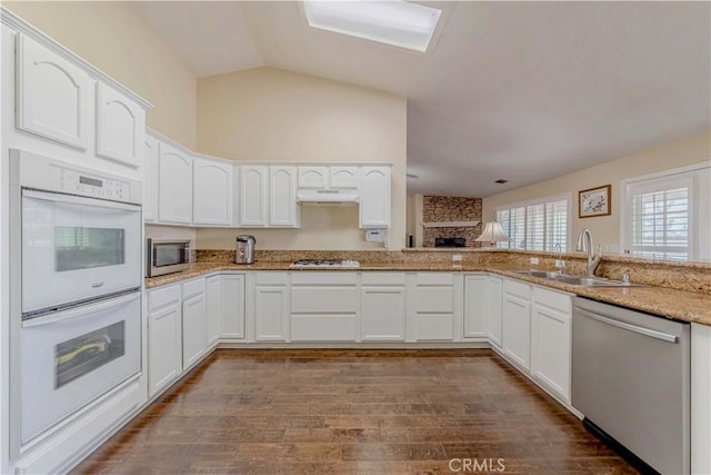 4428 Trumbo Ct, Phelan, CA 92371 - kitchen featuring appliances with stainless steel finishes, a sink, under cabinet range hood, light stone counters, and dark wood-style flooring