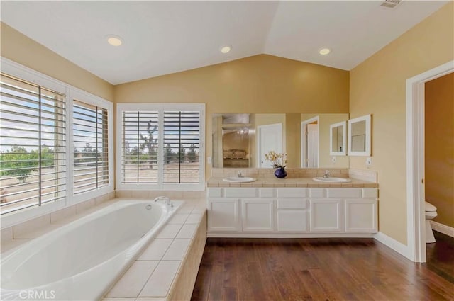 4428 Trumbo Ct, Phelan, CA 92371 - bathroom with toilet, lofted ceiling, a bath, wood finished floors, and double vanity