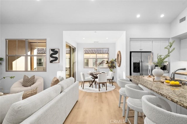 living area featuring light wood-style floors and recessed lighting