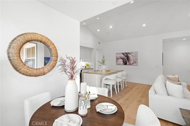 dining space with light wood finished floors, recessed lighting, and high vaulted ceiling