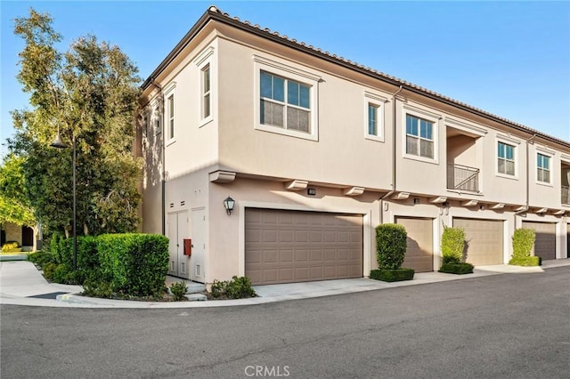 multi unit property with stucco siding and a garage