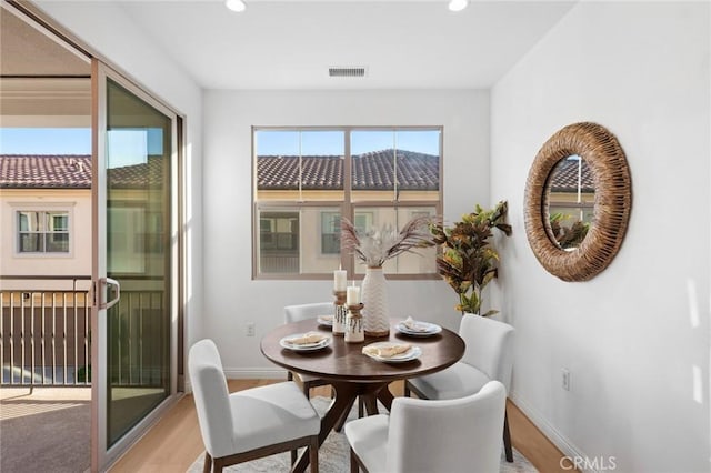 dining space with baseboards, light wood-style flooring, and recessed lighting