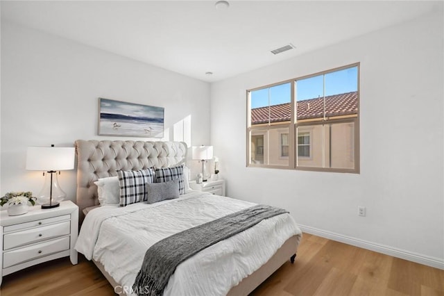 bedroom featuring wood finished floors and baseboards