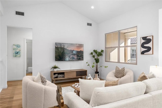 living area featuring wood finished floors, baseboards, recessed lighting, and high vaulted ceiling