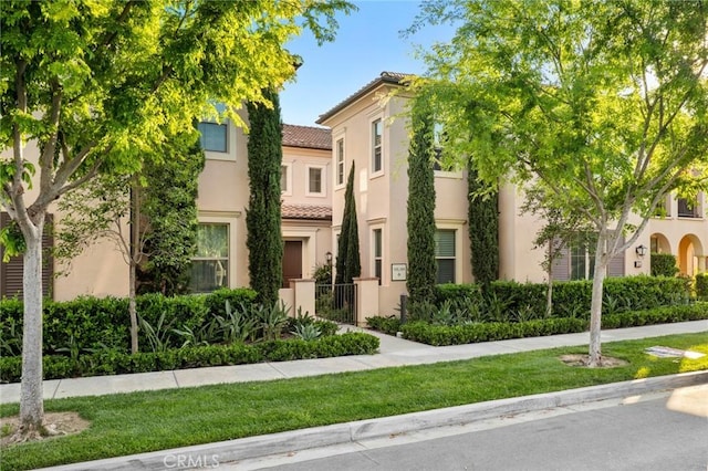 view of front of house featuring a tiled roof and stucco siding