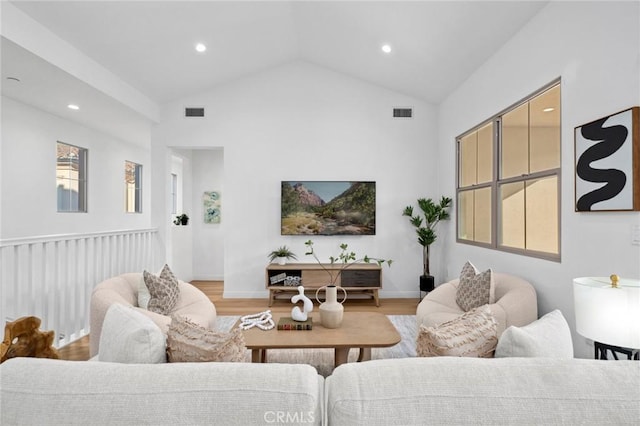 living area featuring light wood finished floors, lofted ceiling, and recessed lighting