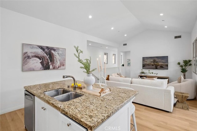 kitchen featuring a sink, open floor plan, light wood-style floors, a kitchen island with sink, and stainless steel dishwasher