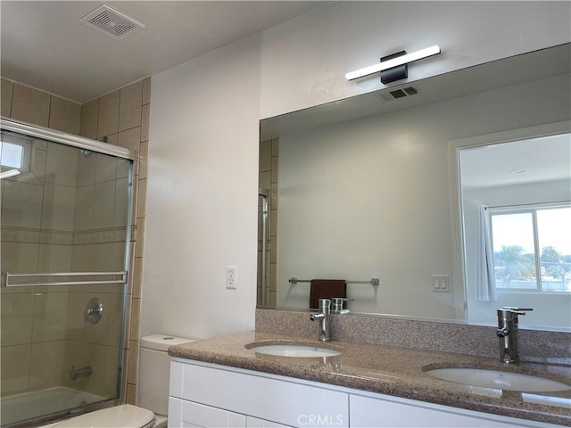 full bathroom with double vanity, toilet, and enclosed tub / shower combo