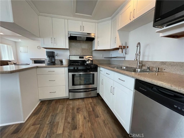 kitchen featuring stainless steel appliances, under cabinet range hood, a sink, and white cabinetry