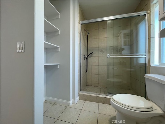 full bathroom featuring tile patterned flooring, toilet, a shower stall, and baseboards