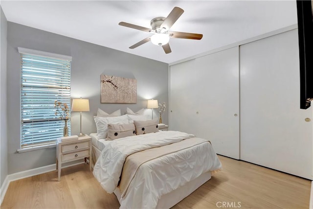 bedroom featuring light wood-type flooring, a closet, and a ceiling fan