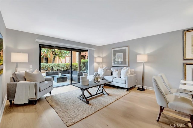 living room featuring light wood finished floors and baseboards