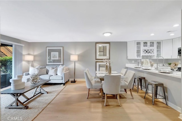 dining area with light wood-style floors, baseboards, and recessed lighting
