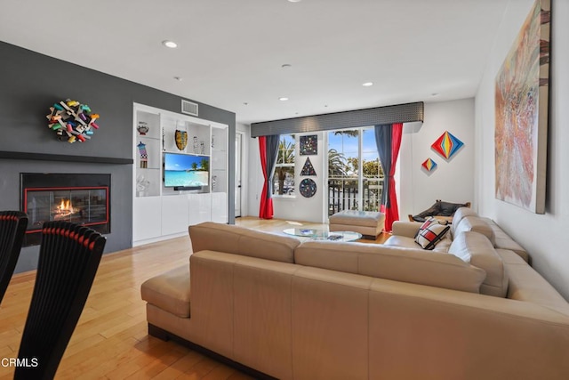 1524 Seabridge Ln, Oxnard, CA 93035 - living area featuring a glass covered fireplace, wood finished floors, recessed lighting, and built in features