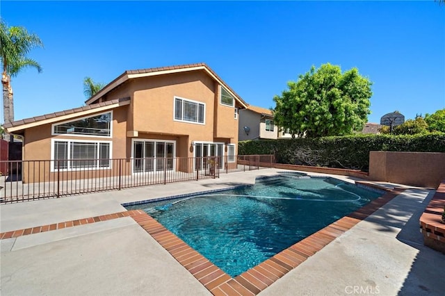 view of swimming pool featuring a patio and fence