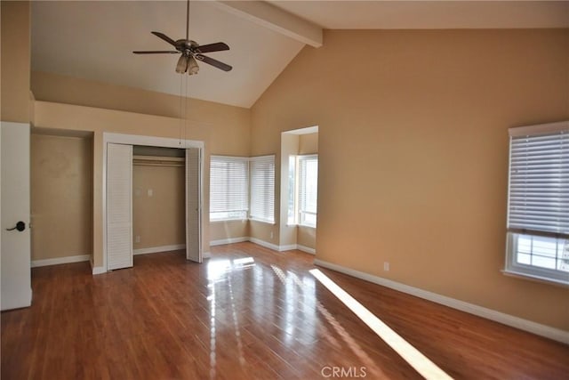 unfurnished bedroom featuring beam ceiling, wood finished floors, high vaulted ceiling, and baseboards