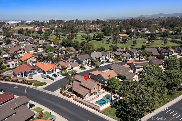 aerial view of residential area featuring a mountain backdrop and a pool area