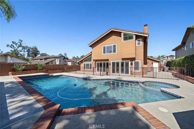 view of pool featuring a fenced backyard, a patio area, and a pool with connected hot tub