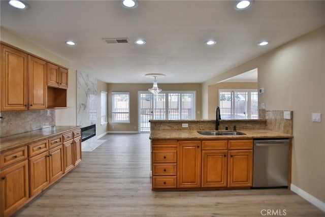 kitchen featuring dishwasher, a sink, baseboards, light wood finished floors, and recessed lighting