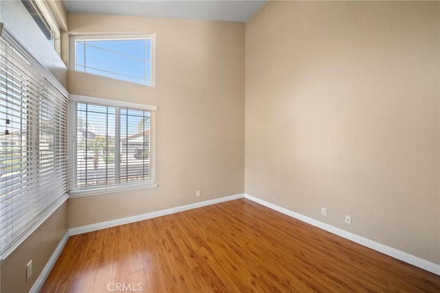 spare room with wood finished floors and baseboards