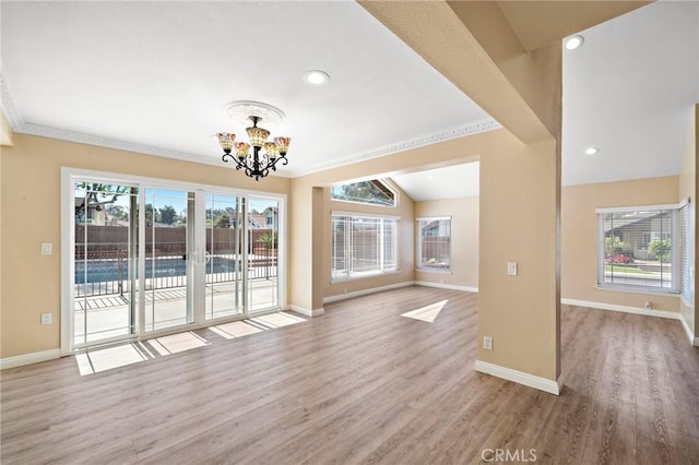 unfurnished living room with a chandelier, wood finished floors, healthy amount of natural light, baseboards, and recessed lighting