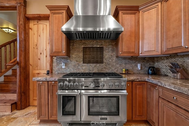 1020 Heritage Trl, Big Bear City, CA 92314 - kitchen with range with two ovens, wall chimney exhaust hood, brown cabinets, and tasteful backsplash
