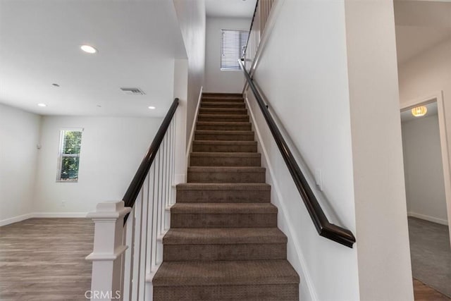 staircase with recessed lighting, baseboards, and wood finished floors