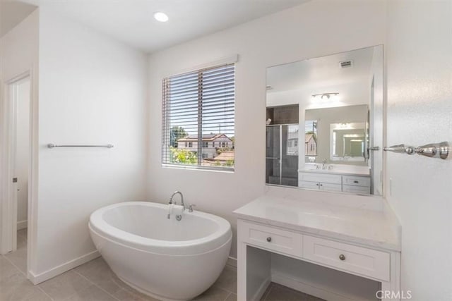 full bathroom featuring a stall shower, a freestanding bath, tile patterned floors, vanity, and baseboards
