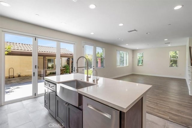 kitchen with a sink, stainless steel dishwasher, plenty of natural light, light countertops, and recessed lighting