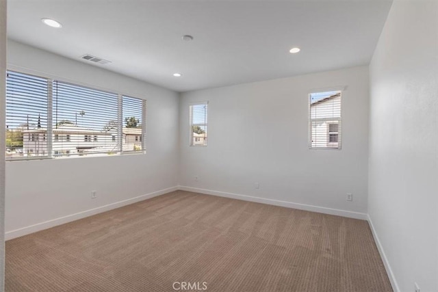 empty room with light colored carpet, healthy amount of natural light, baseboards, and recessed lighting