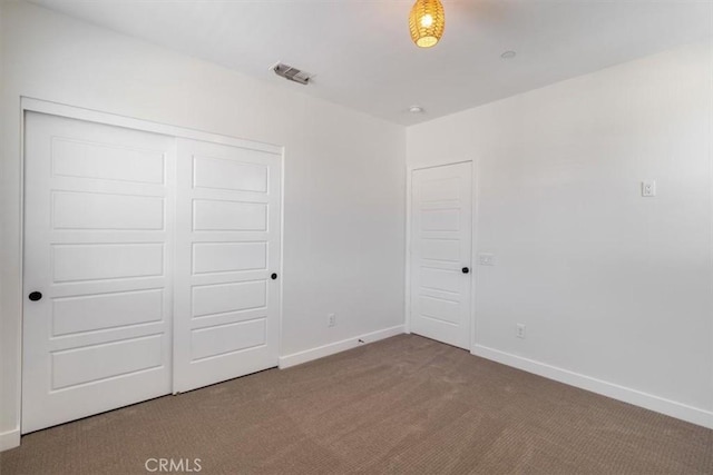 unfurnished bedroom with carpet floors, baseboards, and a closet