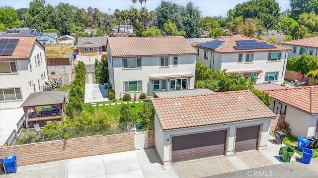view of front of home featuring a residential view, stucco siding, a tile roof, fence, and driveway
