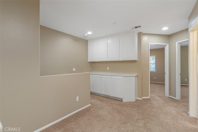 empty room featuring light colored carpet, baseboards, and recessed lighting