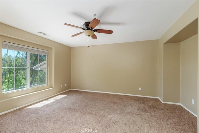 spare room with carpet, ceiling fan, and baseboards