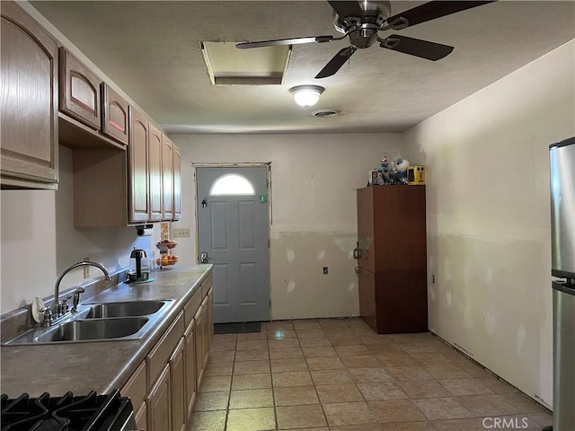 12409 Stamper Rd, Girard, IL 62640 - kitchen featuring a sink, a ceiling fan, a textured ceiling, stove, and freestanding refrigerator