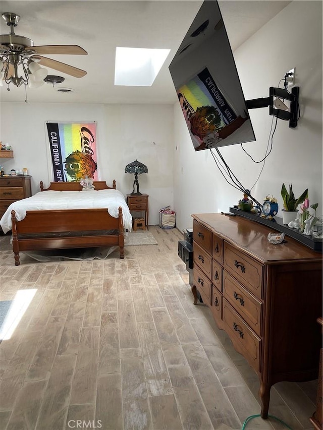 12409 Stamper Rd, Girard, IL 62640 - bedroom featuring a skylight, light wood-style flooring, and ceiling fan