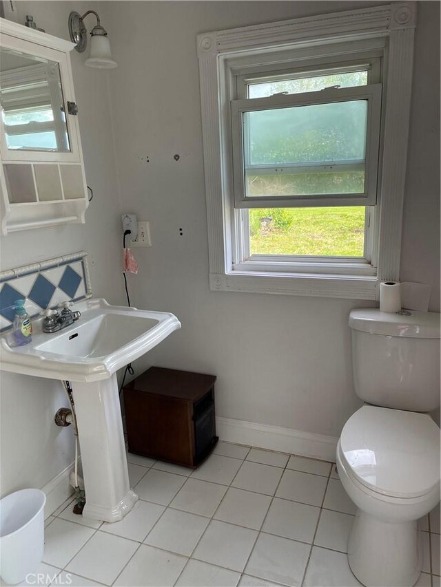 12409 Stamper Rd, Girard, IL 62640 - bathroom with plenty of natural light, toilet, baseboards, and tile patterned flooring
