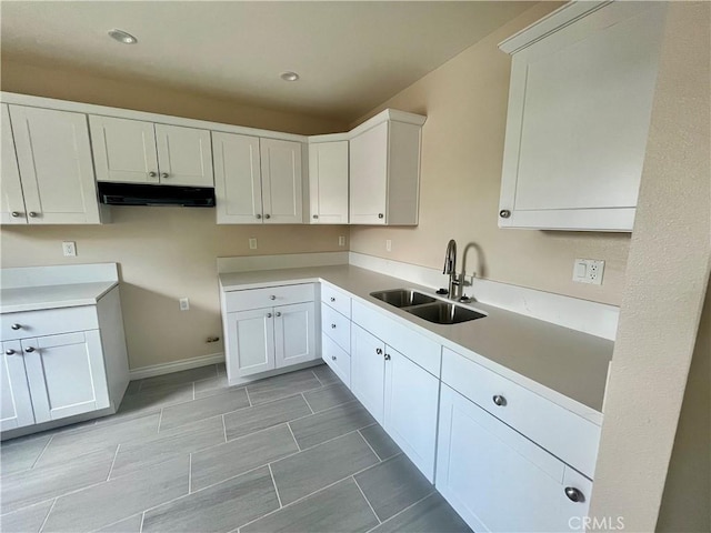 1657 N J St, San Bernardino, CA 92411 - kitchen featuring a sink, under cabinet range hood, white cabinets, baseboards, and recessed lighting