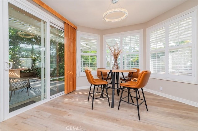 dining room featuring baseboards, wood finished floors, and healthy amount of natural light