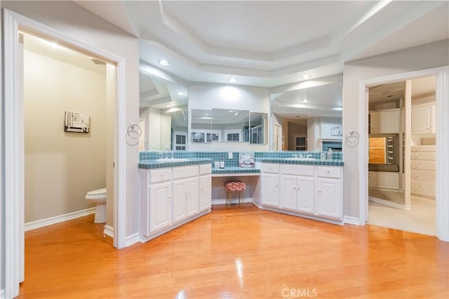 full bath with tasteful backsplash, wood finished floors, recessed lighting, toilet, and vanity