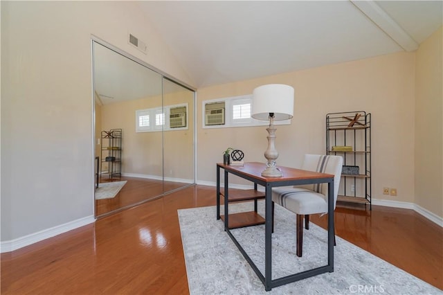 office featuring lofted ceiling, wood finished floors, and baseboards