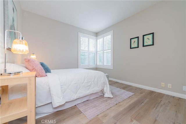 bedroom with wood finished floors and baseboards