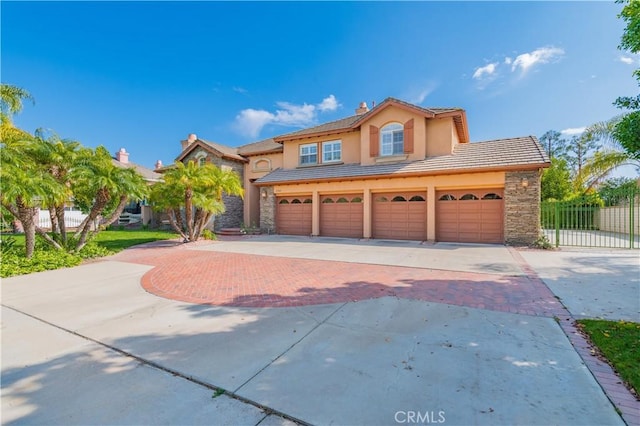 view of front of property featuring fence, decorative driveway, stone siding, a tile roof, and stucco siding