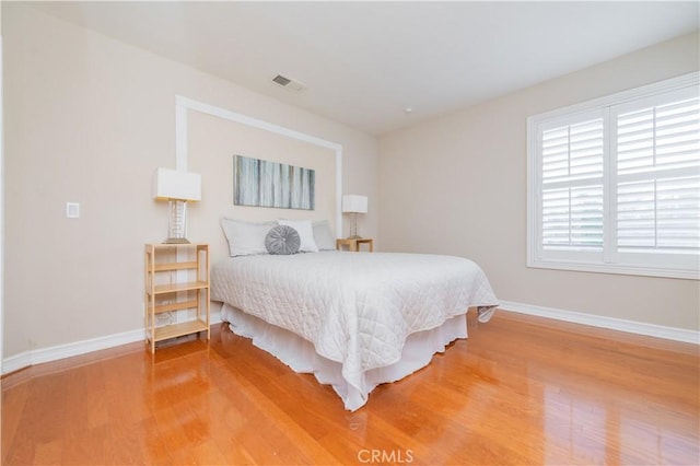 bedroom featuring light wood-style floors and baseboards