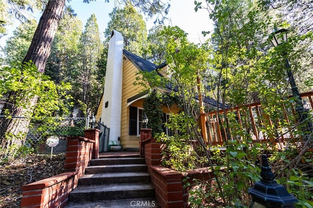 222 Holiday Dr, Lake Arrowhead, CA 92352 - view of front facade featuring fence and a chimney