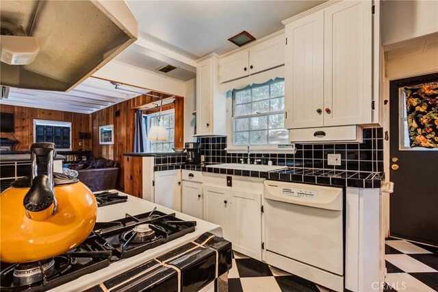 222 Holiday Dr, Lake Arrowhead, CA 92352 - kitchen featuring dishwasher, dark flooring, tile counters, a sink, and wooden walls