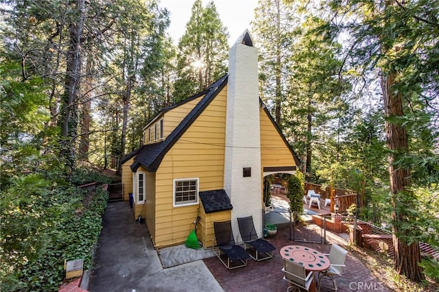222 Holiday Dr, Lake Arrowhead, CA 92352 - rear view of house featuring a patio area and a chimney