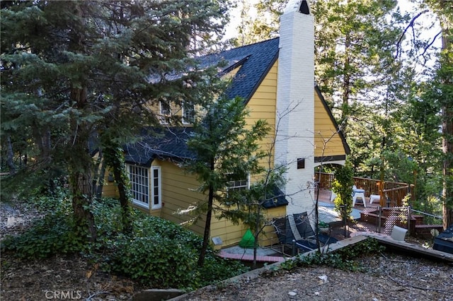 222 Holiday Dr, Lake Arrowhead, CA 92352 - view of side of home featuring a deck, a chimney, and roof with shingles