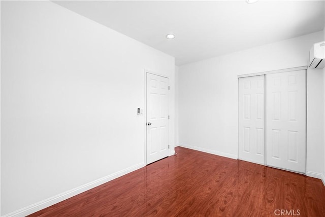 507 S Gaybar Ave, West Covina, CA 91790 - unfurnished bedroom featuring wood finished floors, a wall unit AC, recessed lighting, baseboards, and a closet