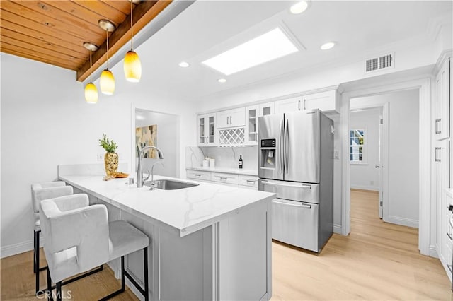 507 S Gaybar Ave, West Covina, CA 91790 - kitchen with stainless steel fridge with ice dispenser, a sink, glass insert cabinets, a peninsula, and a kitchen bar